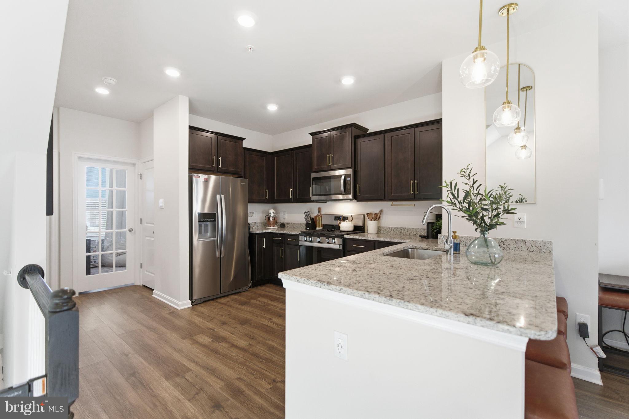 715 Courier Lane Frederick, MD 21701 - Photo 9 of 26 a kitchen with stainless steel appliances granite countertop a refrigerator sink and cabinets