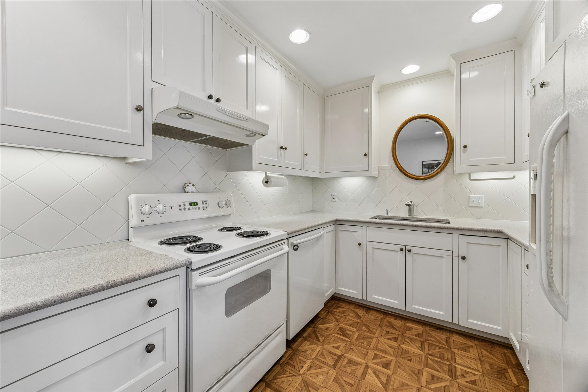 1801 Lavaca Street, Unit 6E Austin, TX 78701 - Photo 6 of 32 Kitchen featuring white appliances, white cabinetry, parquet flooring, and recessed lighting