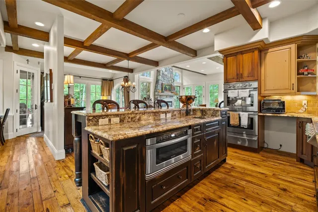 a kitchen with stainless steel appliances granite countertop a stove and a wooden floors