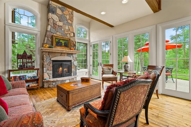 a living room with furniture fireplace and large windows