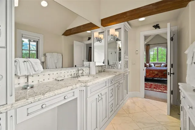 a spacious bathroom with a granite countertop sink mirror and shower