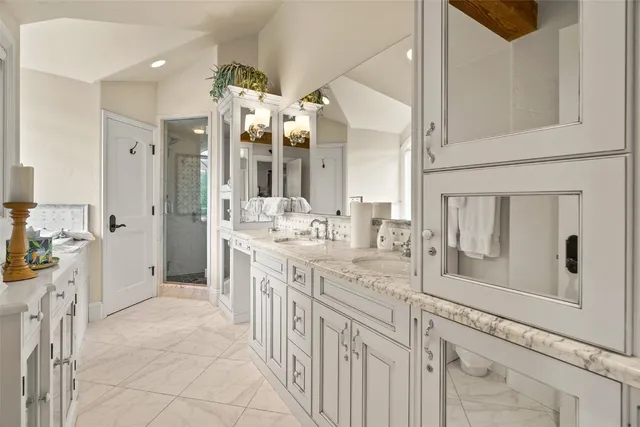 a bathroom with a double vanity sink mirror and shower