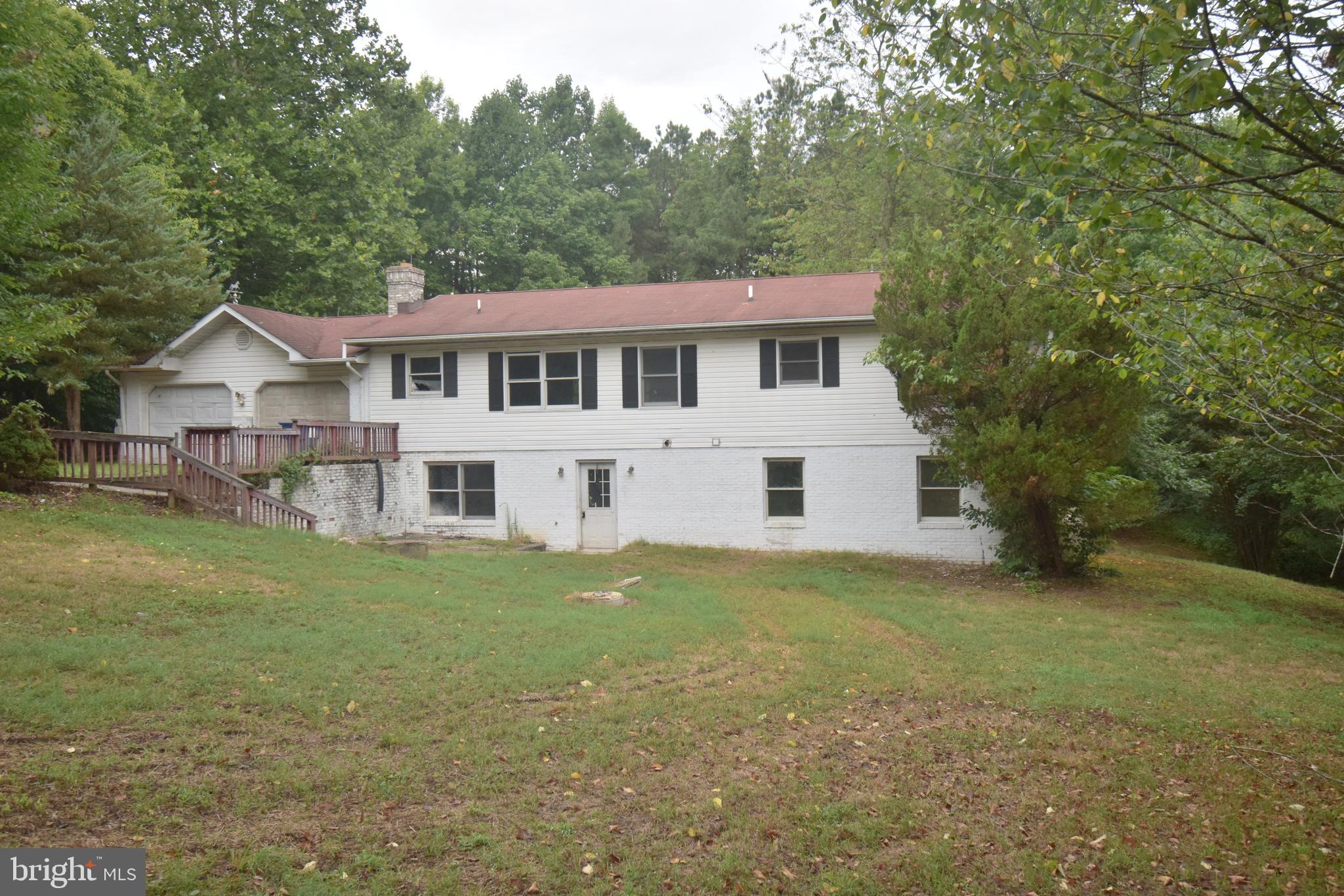 a view of a yard in front of a house with large trees