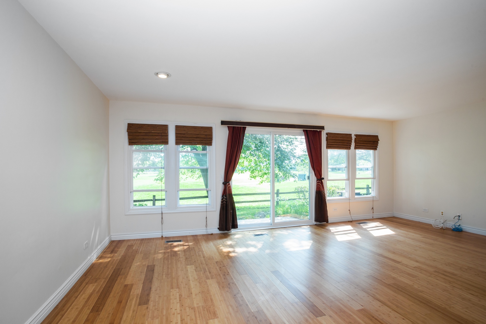 153 Inverness Court Elk Grove Village, IL 60007 - Photo 2 of 16 an empty room with wooden floor and windows