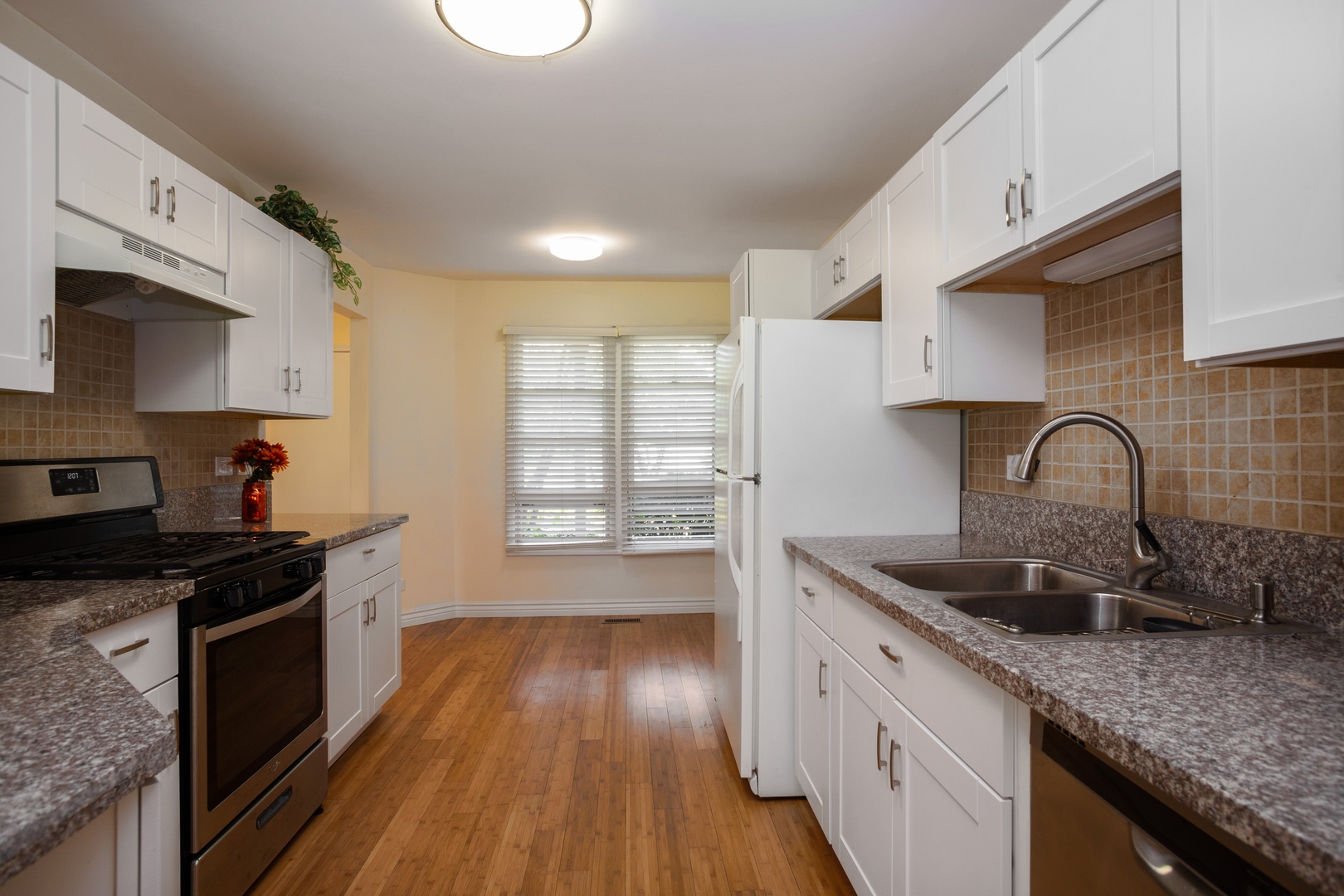 153 Inverness Court Elk Grove Village, IL 60007 - Photo 4 of 16 a kitchen with granite countertop stainless steel appliances a sink stove top oven and cabinets