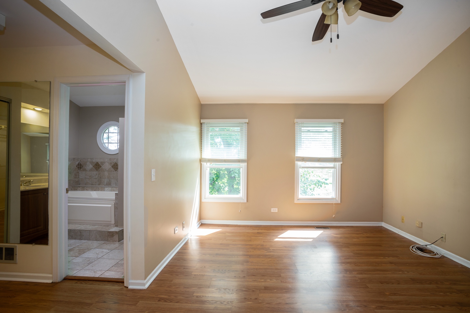 153 Inverness Court Elk Grove Village, IL 60007 - Photo 7 of 16 an empty room with wooden floor and windows