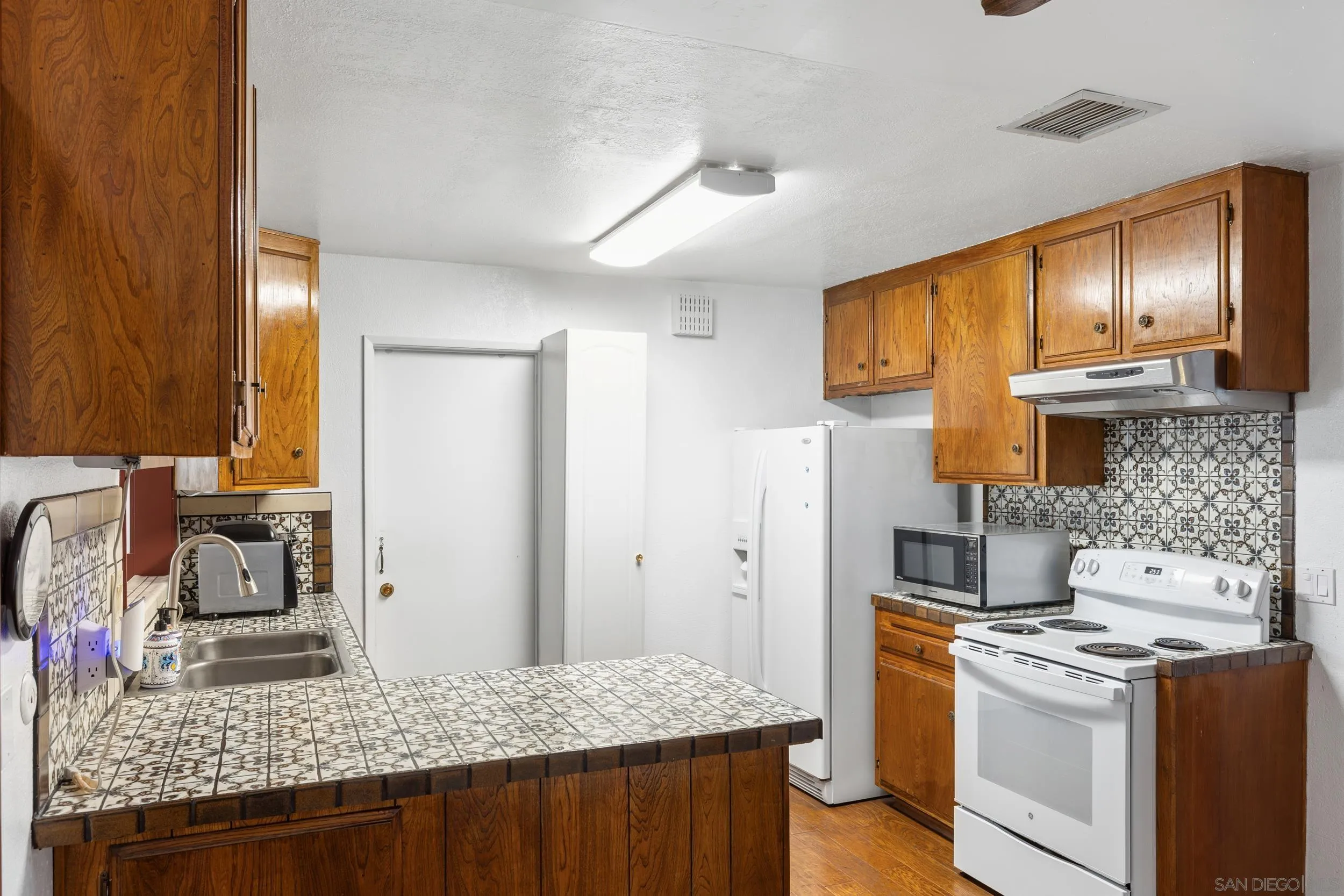 538 Paraiso Avenue Spring Valley, CA 91977 - Photo 3 of 17 a kitchen with a stove and a refrigerator