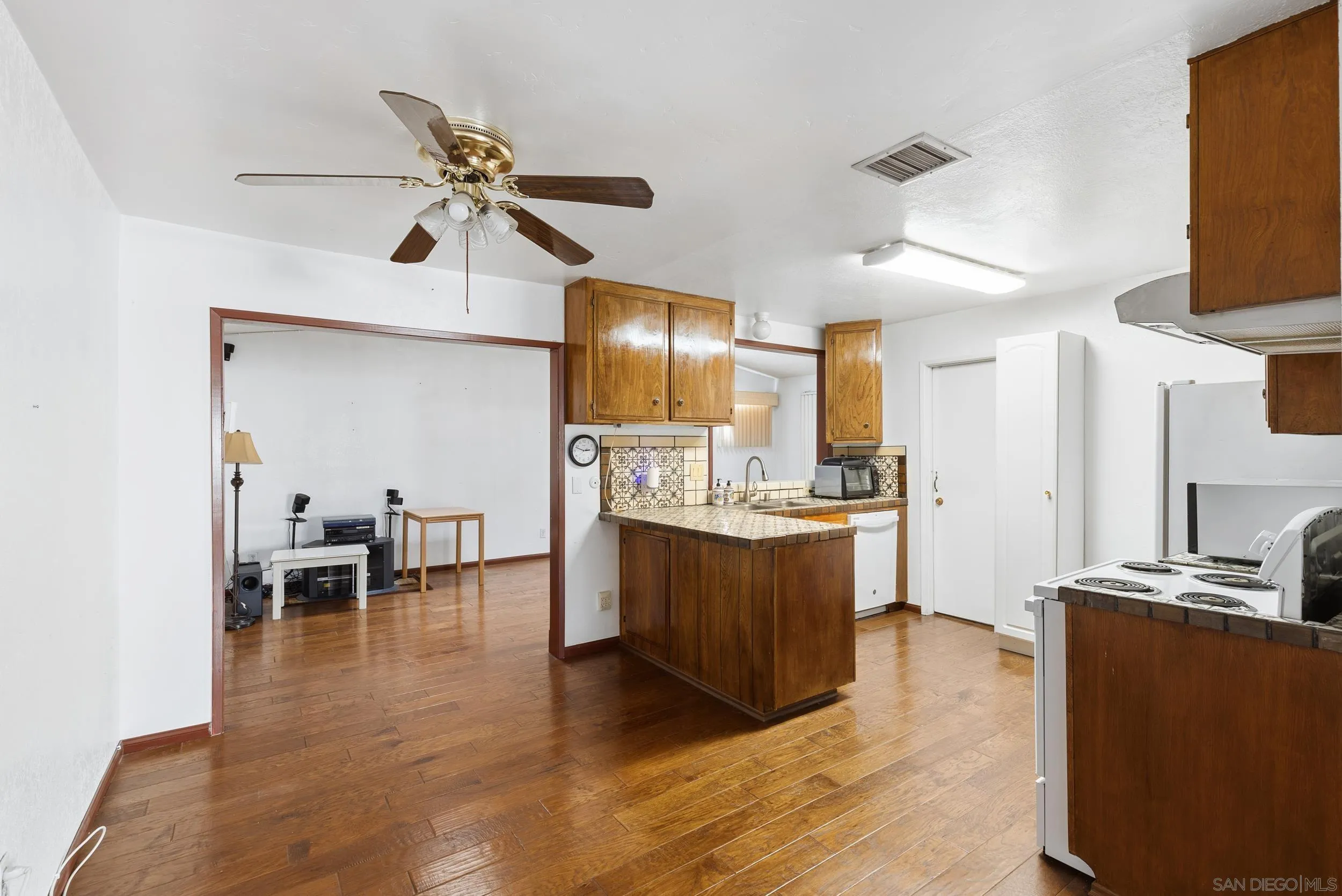 538 Paraiso Avenue Spring Valley, CA 91977 - Photo 4 of 17 a kitchen with stainless steel appliances kitchen island granite countertop a table chairs in it and wooden floors