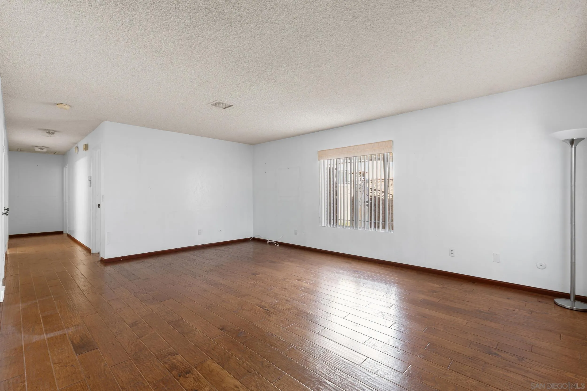 538 Paraiso Avenue Spring Valley, CA 91977 - Photo 6 of 17 a view of an empty room with wooden floor and a window
