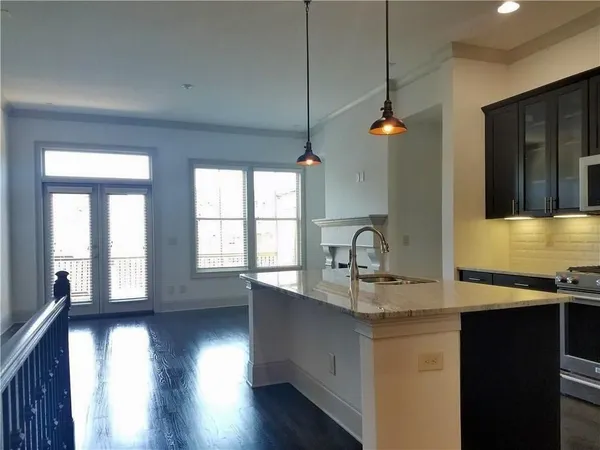 a kitchen with stainless steel appliances granite countertop a sink stove and wooden floor