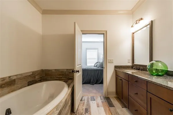 a spacious bathroom with a granite countertop tub sink and mirror