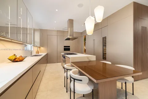 a kitchen with stainless steel appliances kitchen island granite countertop a table chairs in it and wooden floors