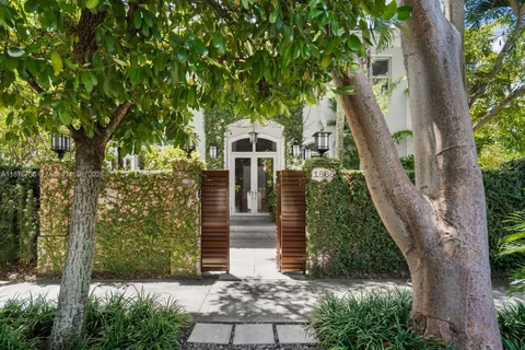 a front view of a house with a tree