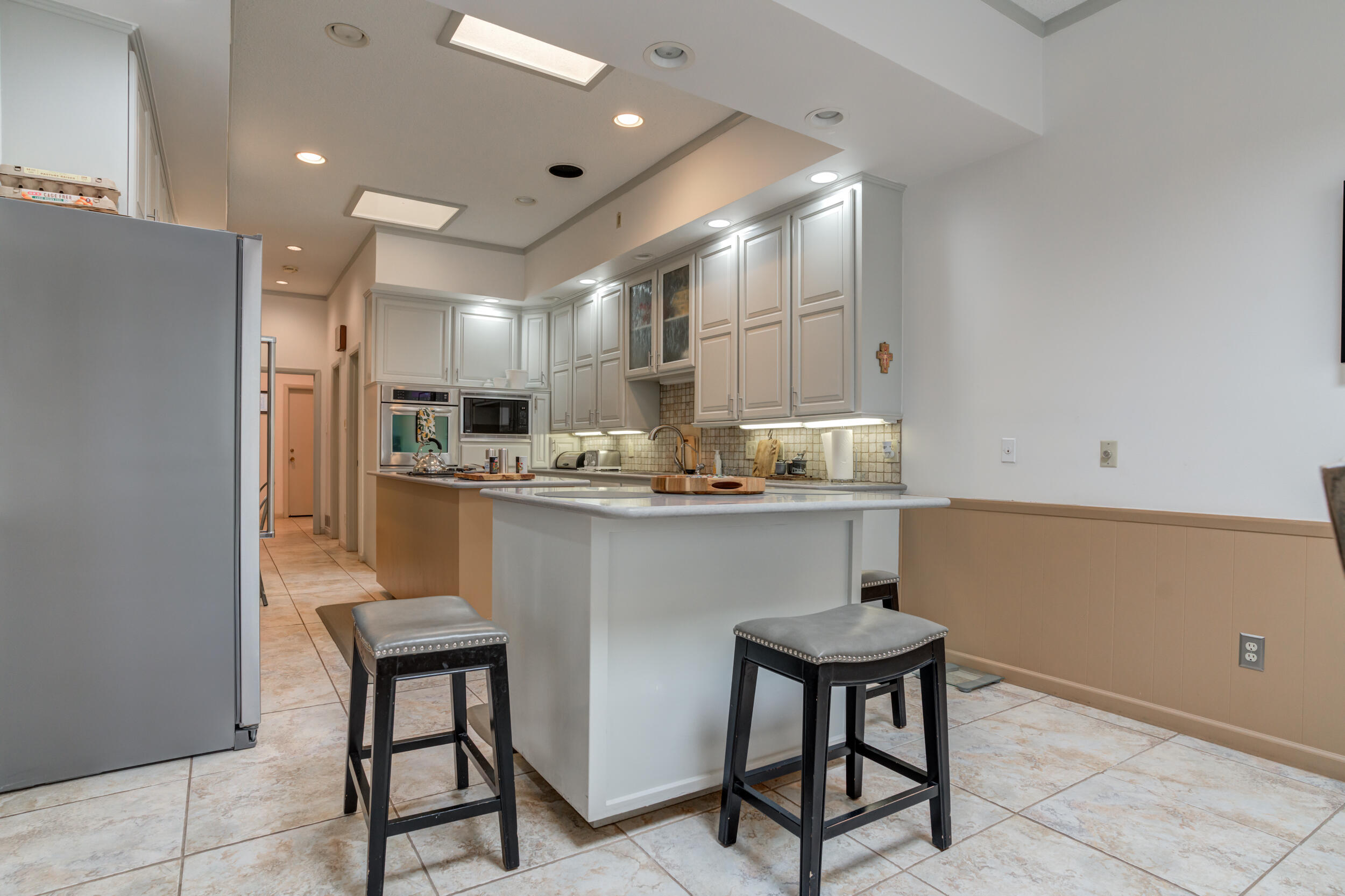 4528 7th Street Lubbock, TX 79416 - Photo 11 of 69 a kitchen with refrigerator a sink and chairs