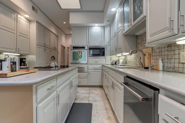 a bathroom with a granite countertop sink and a toilet