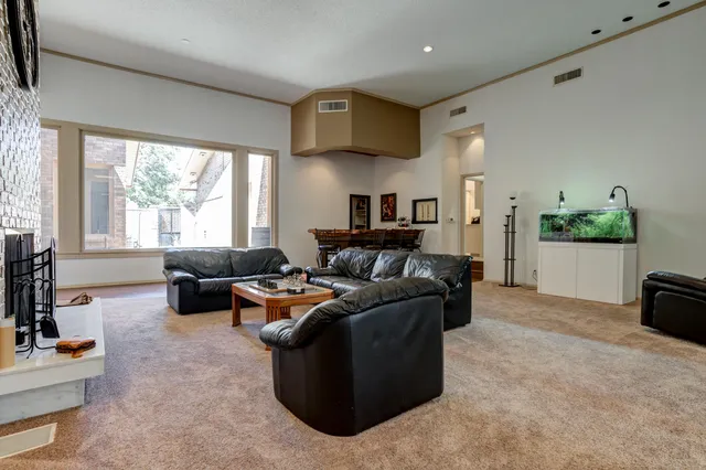 a living room with furniture a clock on wall and a fireplace