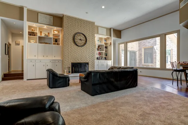 a living room with furniture a flat screen tv and a large window