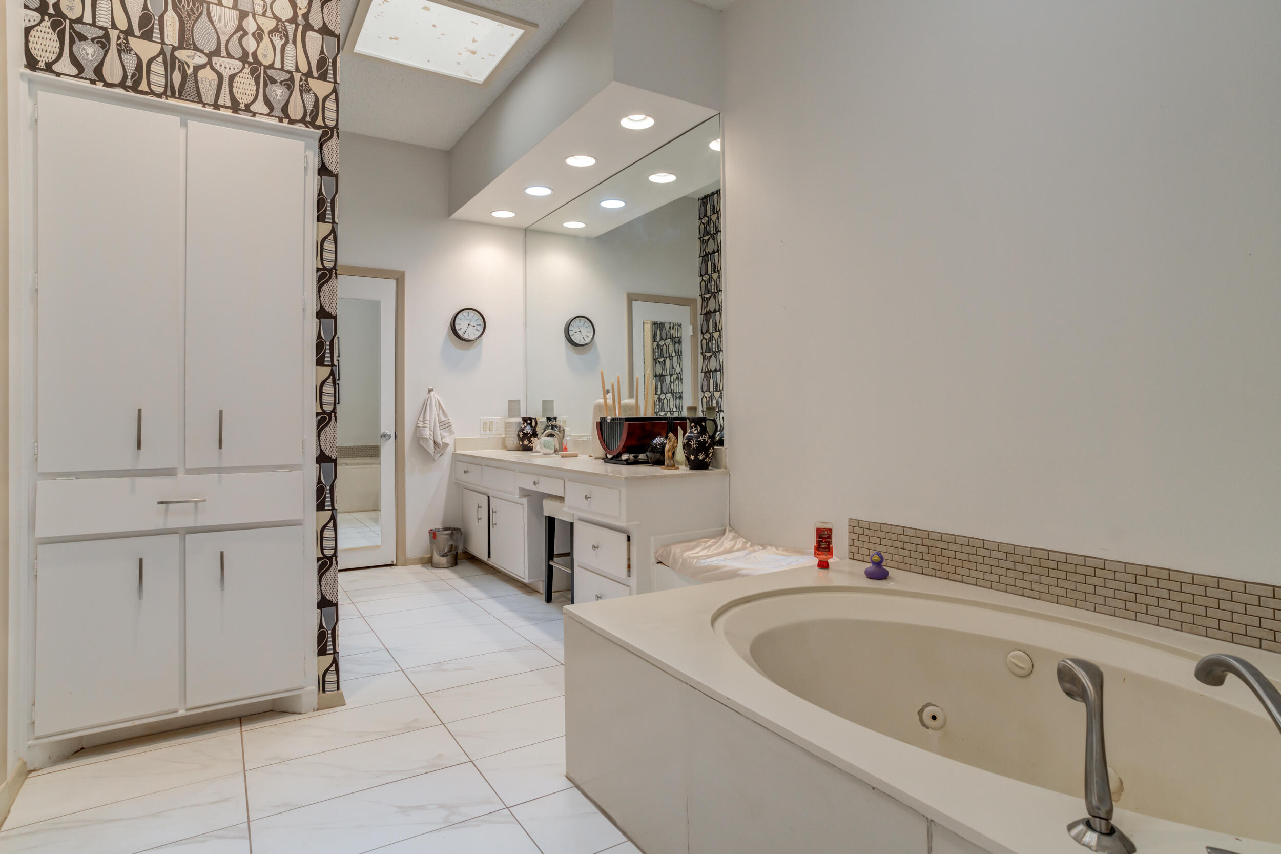4528 7th Street Lubbock, TX 79416 - Photo 43 of 69 a bathroom with a bathtub sink a mirror and shower
