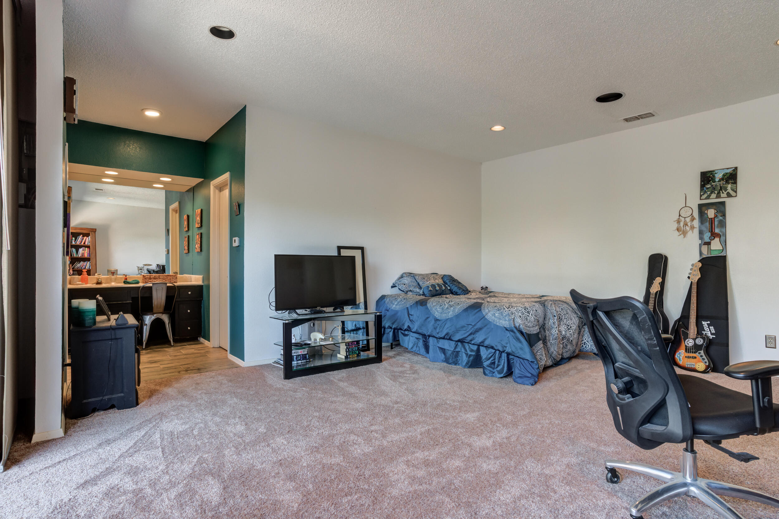 4528 7th Street Lubbock, TX 79416 - Photo 50 of 69 a living room with furniture a flat screen tv and gym equipment