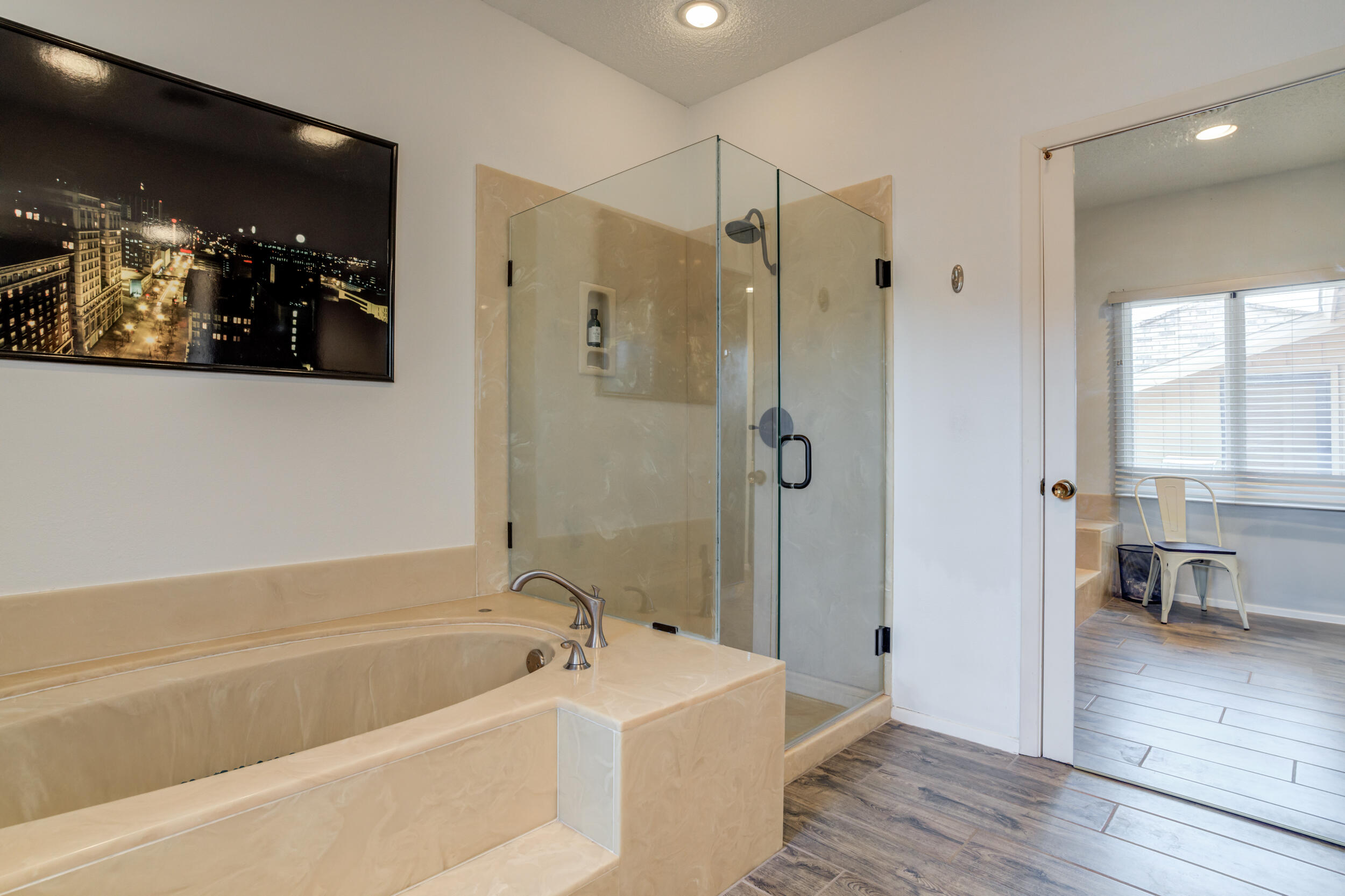4528 7th Street Lubbock, TX 79416 - Photo 56 of 69 a bathroom with a tub a sink and mirrors