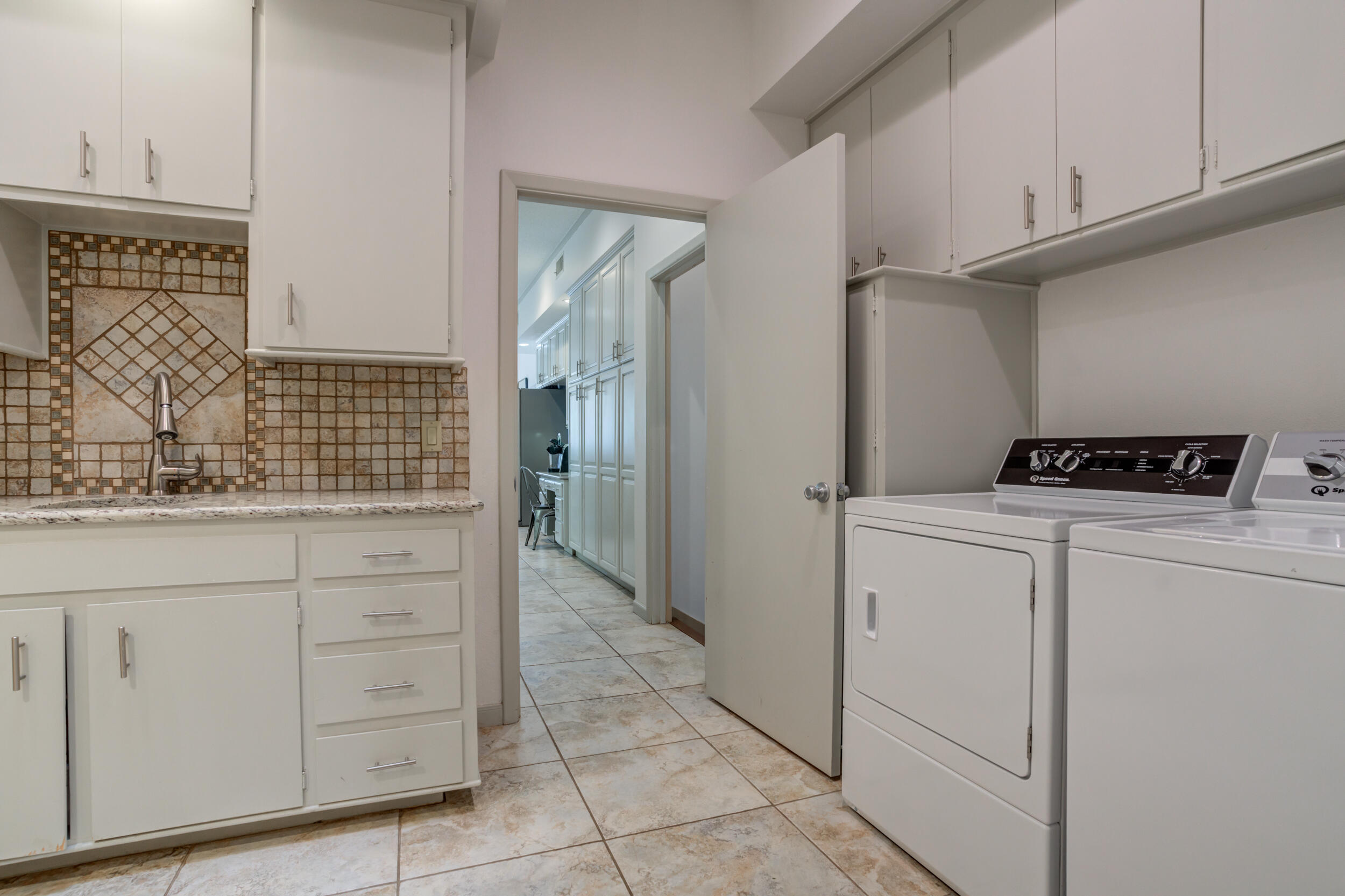 4528 7th Street Lubbock, TX 79416 - Photo 61 of 69 a utility room with cabinets washer and dryer