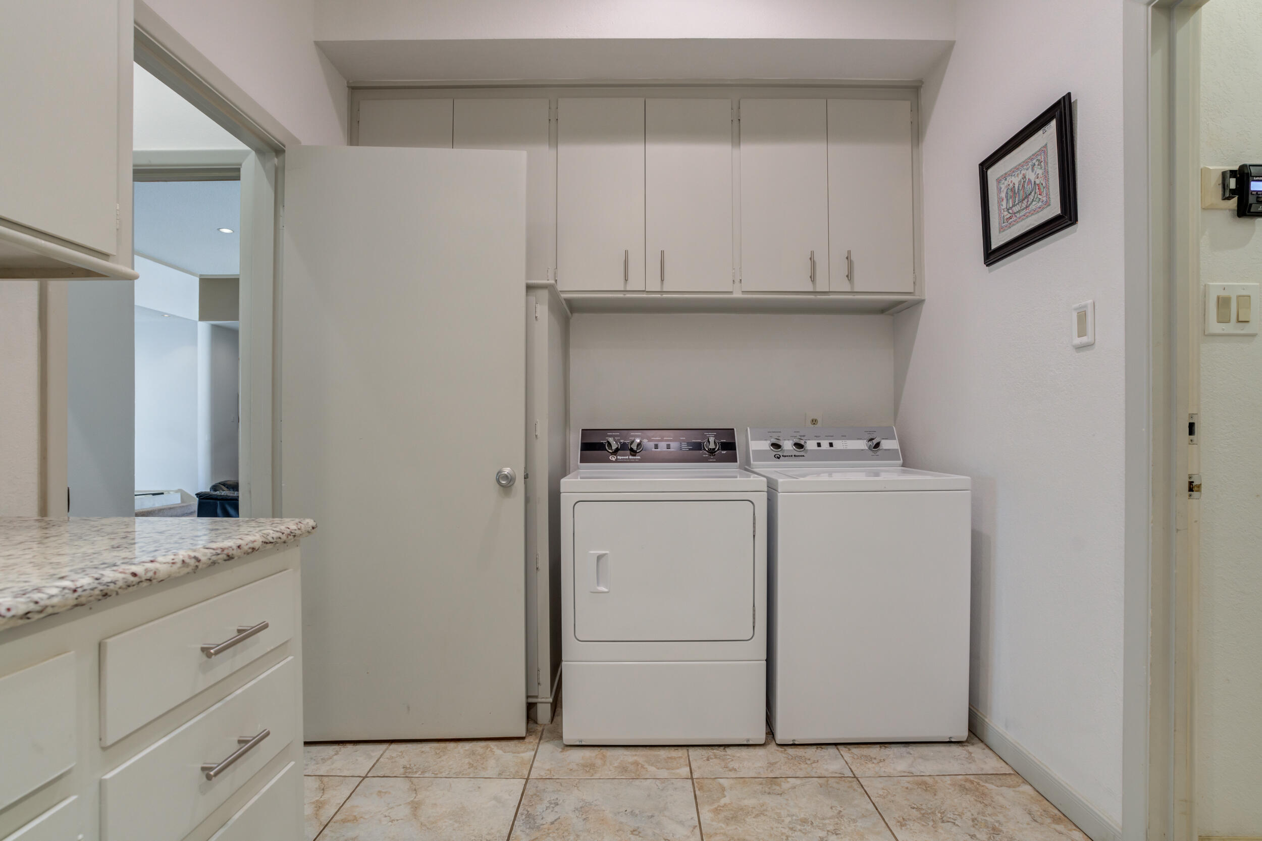 4528 7th Street Lubbock, TX 79416 - Photo 62 of 69 a utility room with cabinets washer and dryer