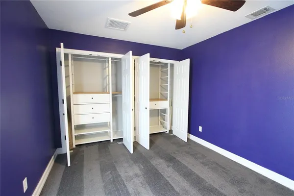 an empty room with a window and a chandelier fan