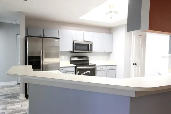 a kitchen with a sink a microwave a refrigerator and cabinets