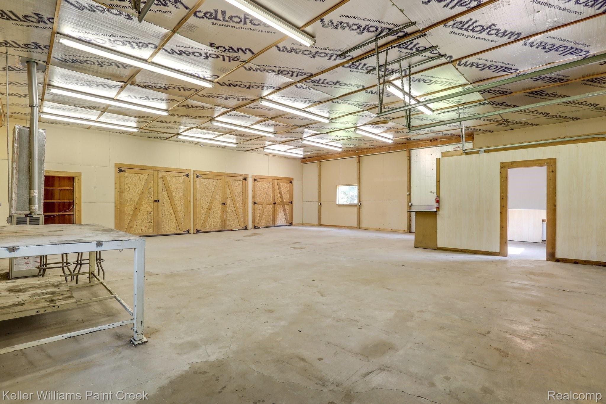 8179 Oakhill Road Clarkston, MI 48348 - Photo 28 of 38 Pole barn is clean with benches and workspaces.