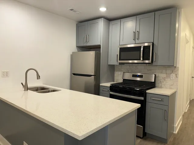 a kitchen with kitchen island a sink appliances and cabinets