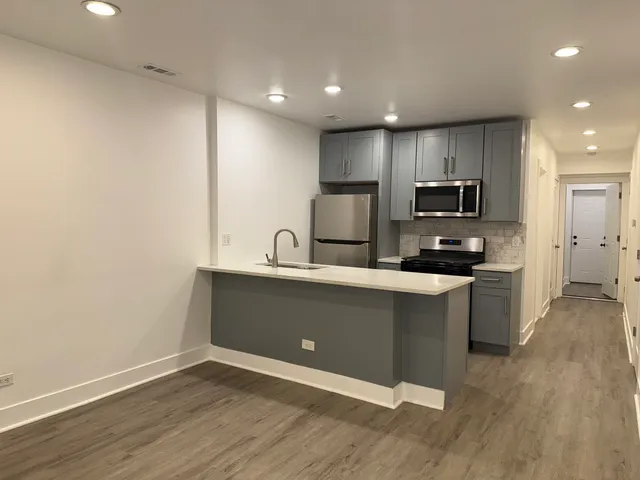 a kitchen with granite countertop white cabinets and stainless steel appliances
