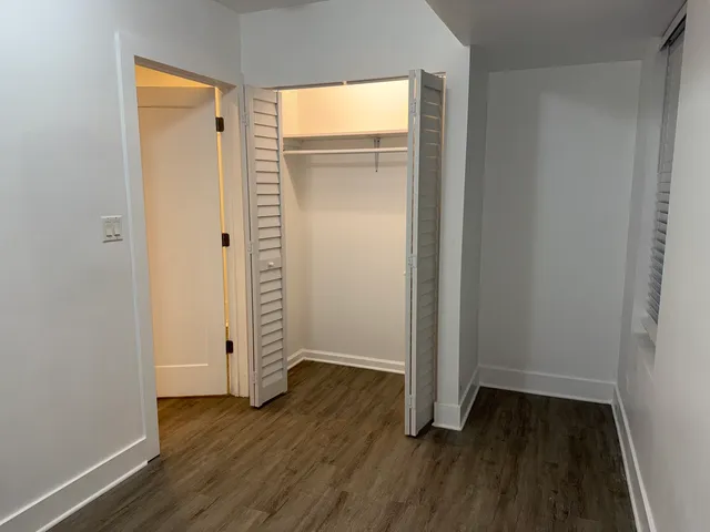 an empty room with wooden floor and closet