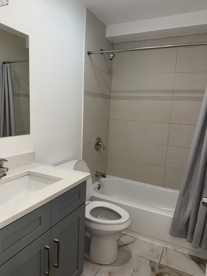 2731 South Homan Avenue, Unit 1 Chicago, IL 60623 - Photo 7 of 10 a bathroom with a sink a toilet and shower