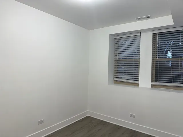 a view of a small space with wooden floor and a window