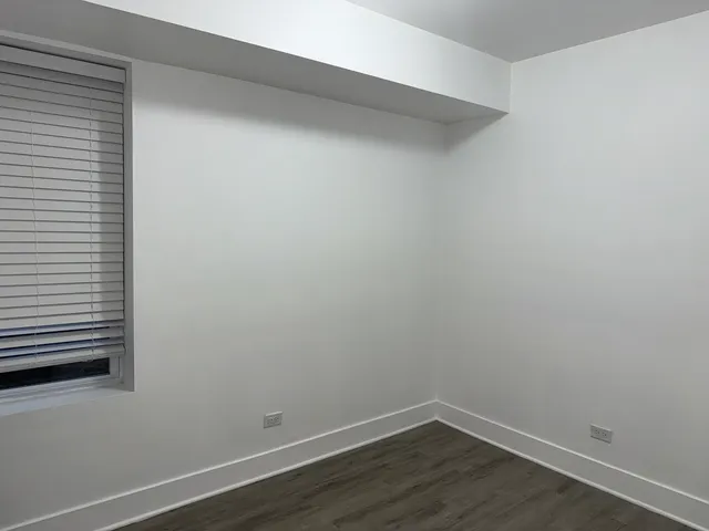 a view of a small space with wooden floor and a window