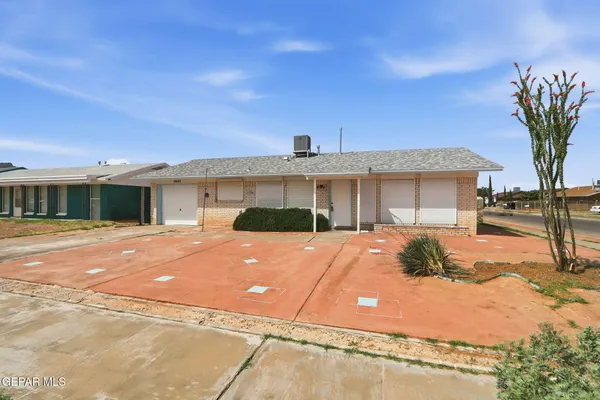 a front view of a house with a yard and potted plants