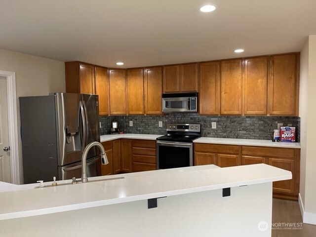 20446 Corbridge Road Southeast Monroe, WA 98272 - Photo 11 of 31 a kitchen with stainless steel appliances granite countertop a refrigerator and a stove top oven