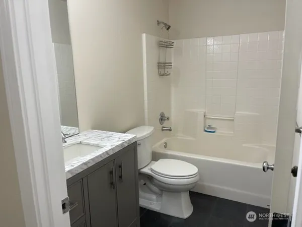 a bathroom with a granite countertop sink toilet and shower