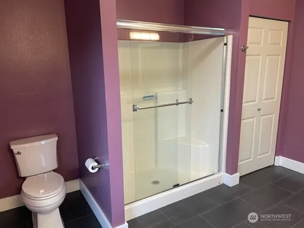 a bathroom with a toilet and a shower