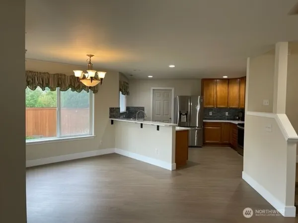 a view of a kitchen with a sink and dishwasher a refrigerator with wooden floor