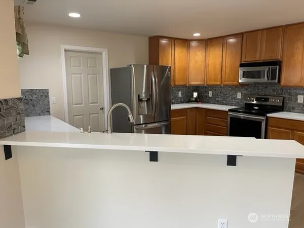 a kitchen with stainless steel appliances a refrigerator sink and microwave
