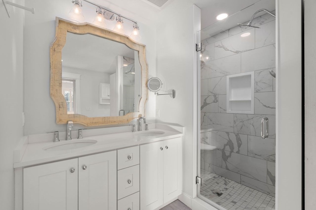 1 Dillingham Avenue Sandwich, MA 02563 - Photo 17 of 36 a bathroom with a granite countertop sink a mirror and a shower