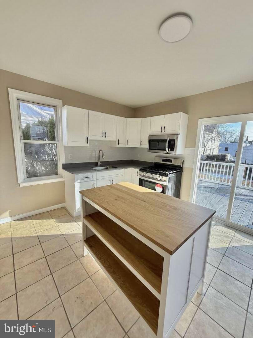136 Webster Street Riverside, NJ 08075 - Photo 2 of 2 a kitchen with stainless steel appliances a stove a sink and a microwave