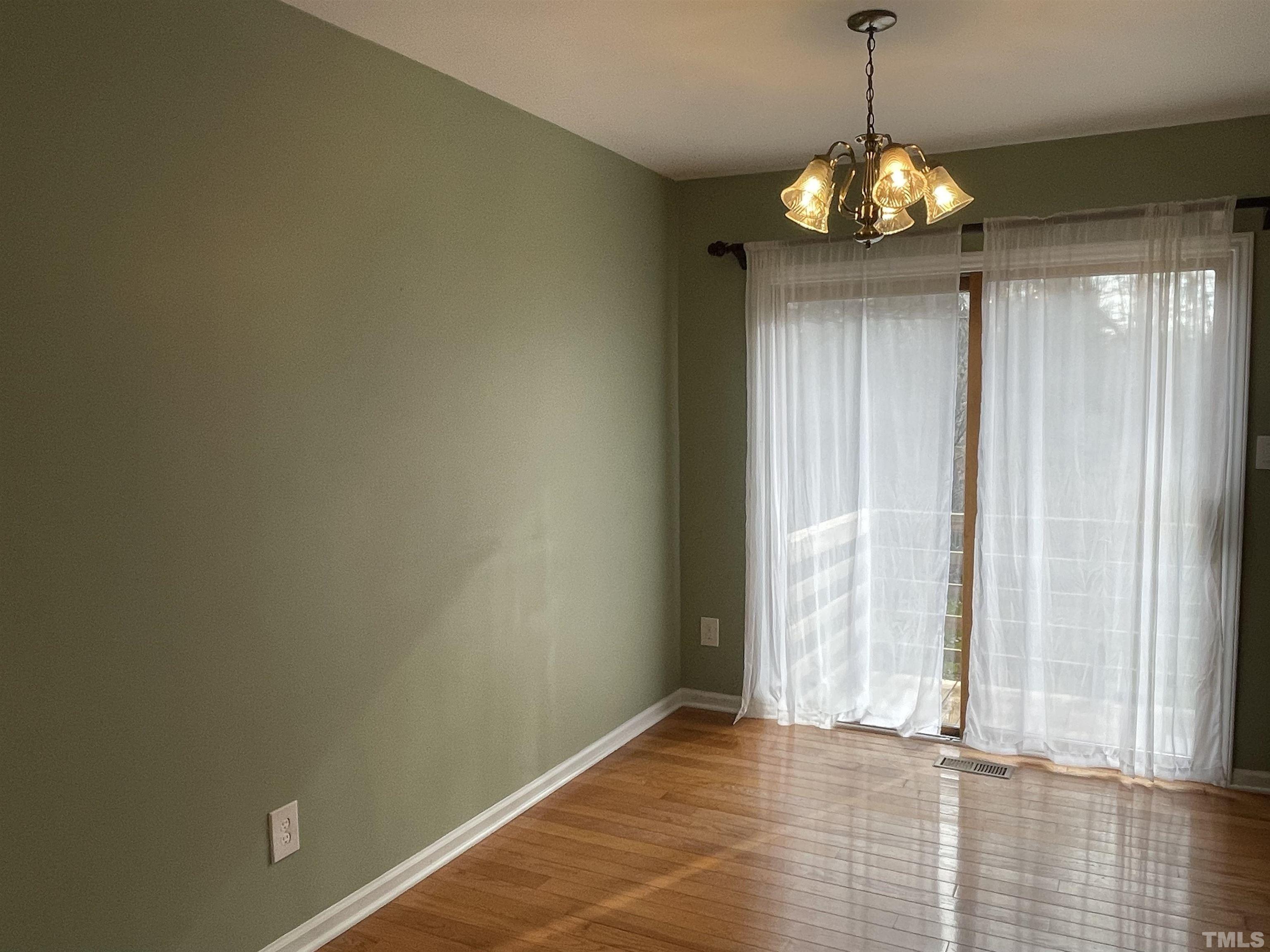 501 Sawmill Road Raleigh, NC 27615 - Photo 6 of 31 a view of an empty room with window and hardwood floor