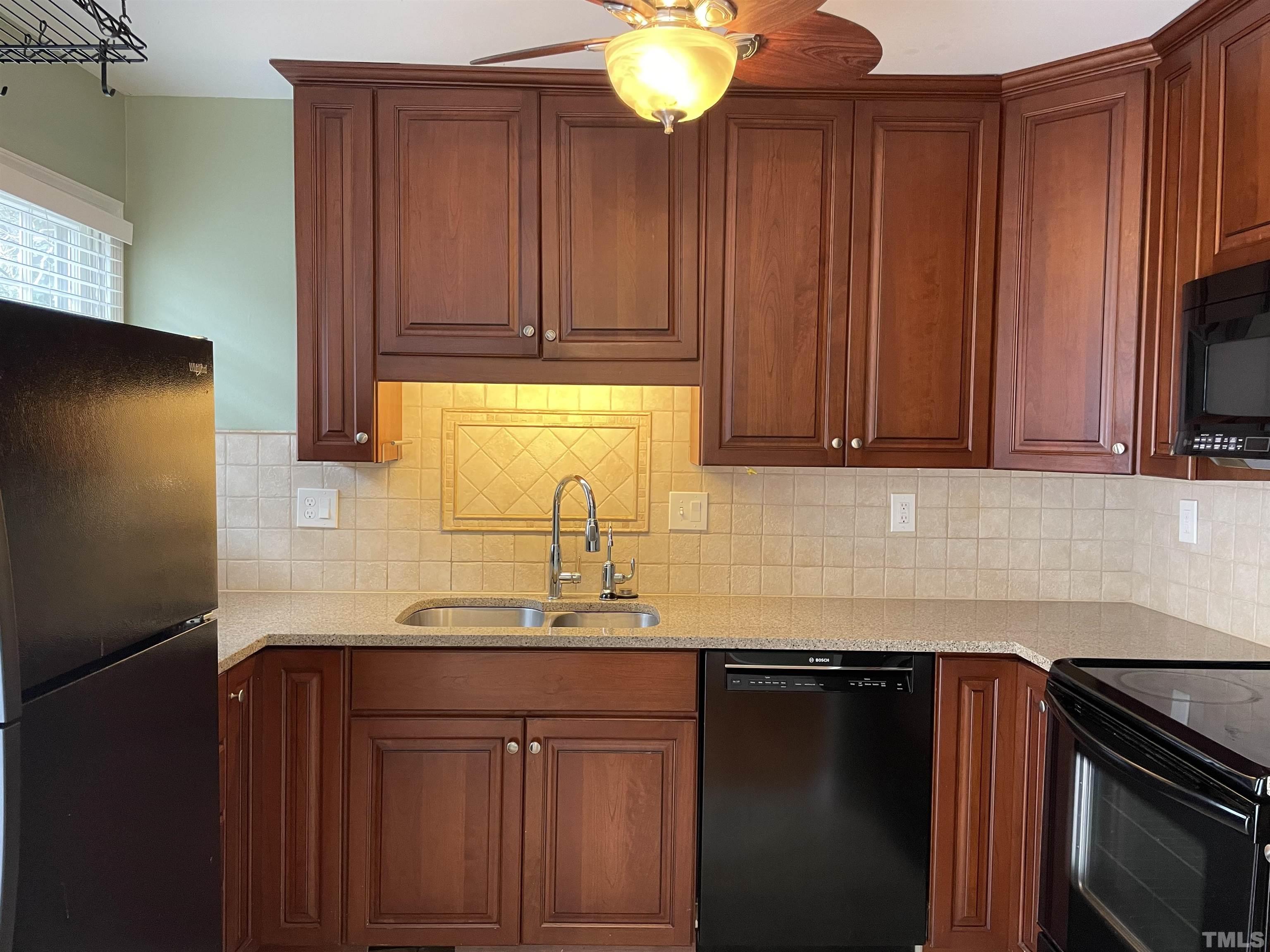 501 Sawmill Road Raleigh, NC 27615 - Photo 7 of 31 a kitchen with granite countertop wood cabinets stainless steel appliances and a sink