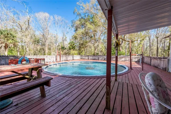 a patio with wooden floor table and chairs