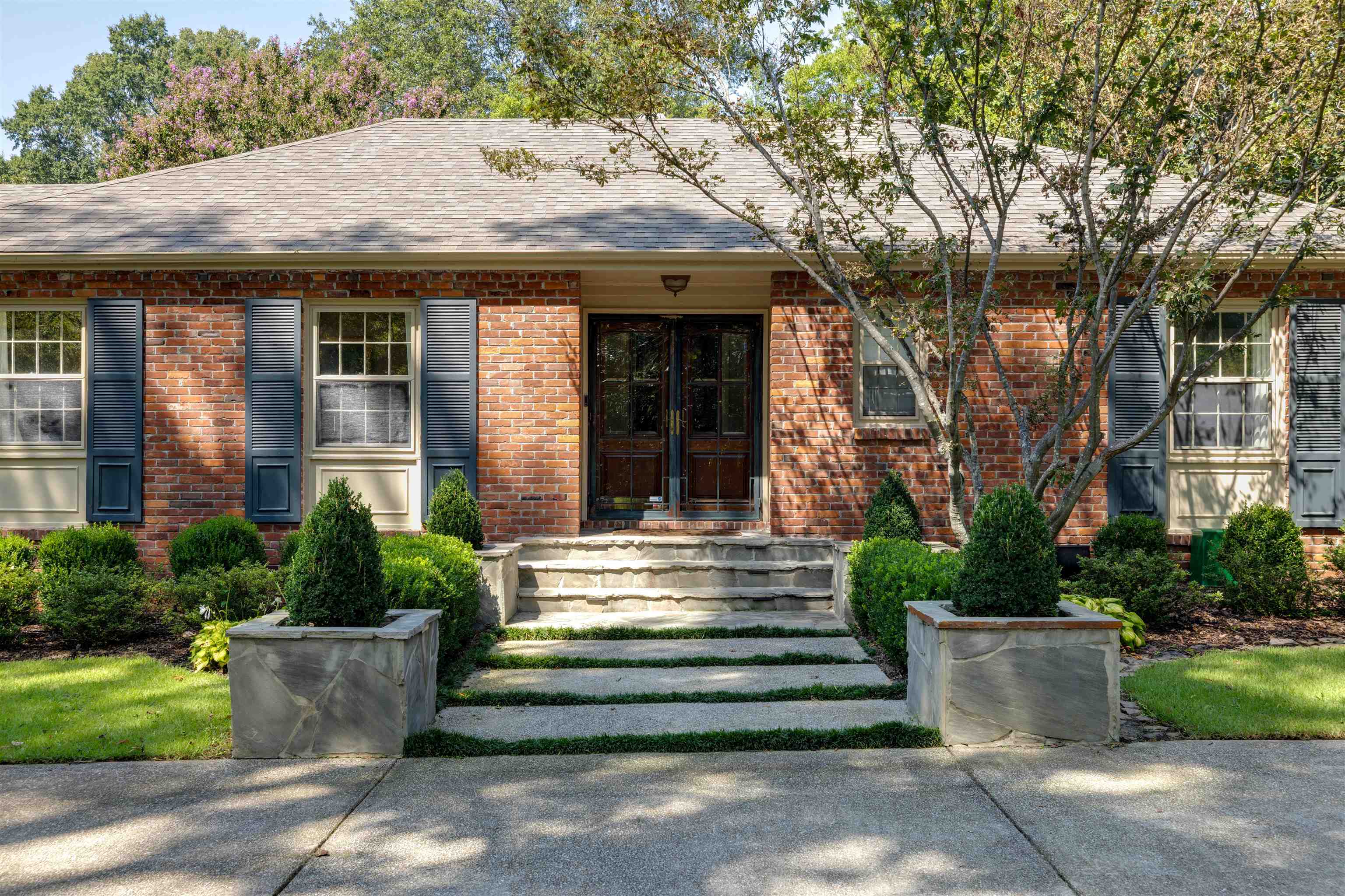 5430 Normandy Road Memphis, TN 38120 - Photo 1 of 32 Such a welcoming entrance, new flagstone front steps, beautiful planters and refinished double doors.