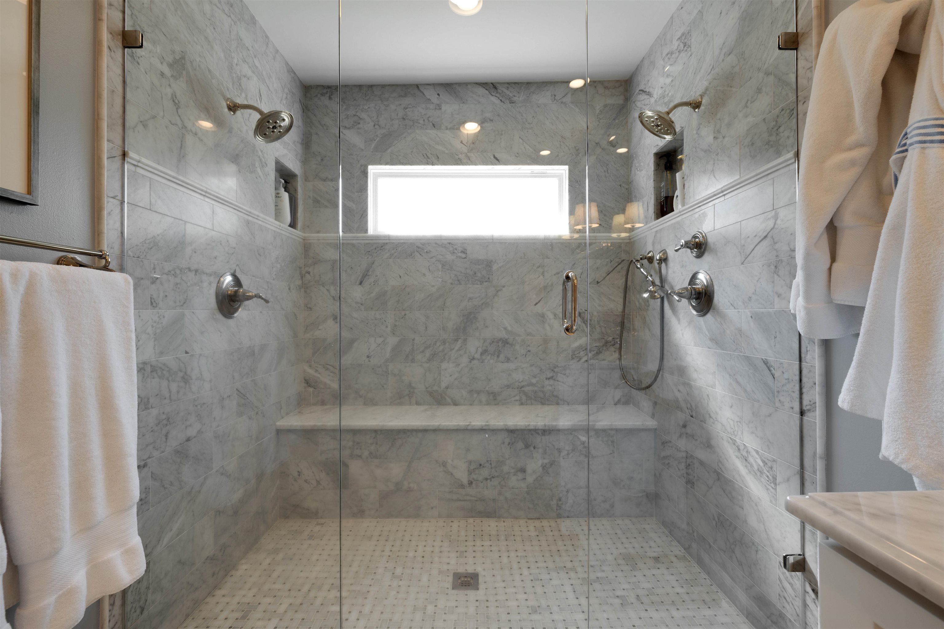 5430 Normandy Road Memphis, TN 38120 - Photo 19 of 32 Carrara Marble tile and shower bench, dual wall shower heads as well as handheld showerhead, new window over shower.