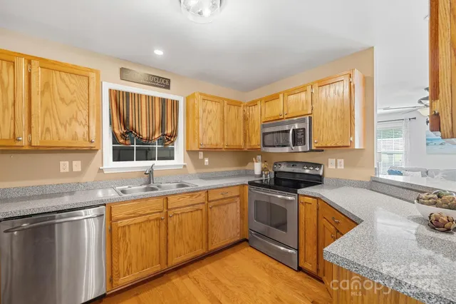 a kitchen with stainless steel appliances granite countertop a sink stove and microwave