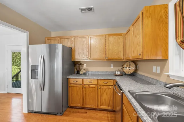 a kitchen with a refrigerator sink and cabinets